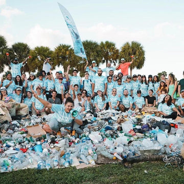 Volunteers at a community cleanup with collected plastic bottles and trash.