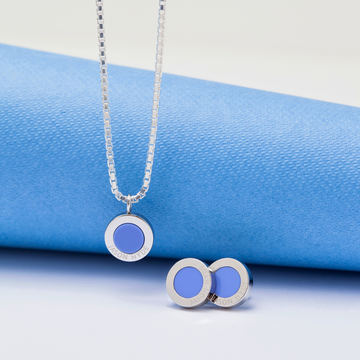 A product shot of a silver necklace and matching stud earrings