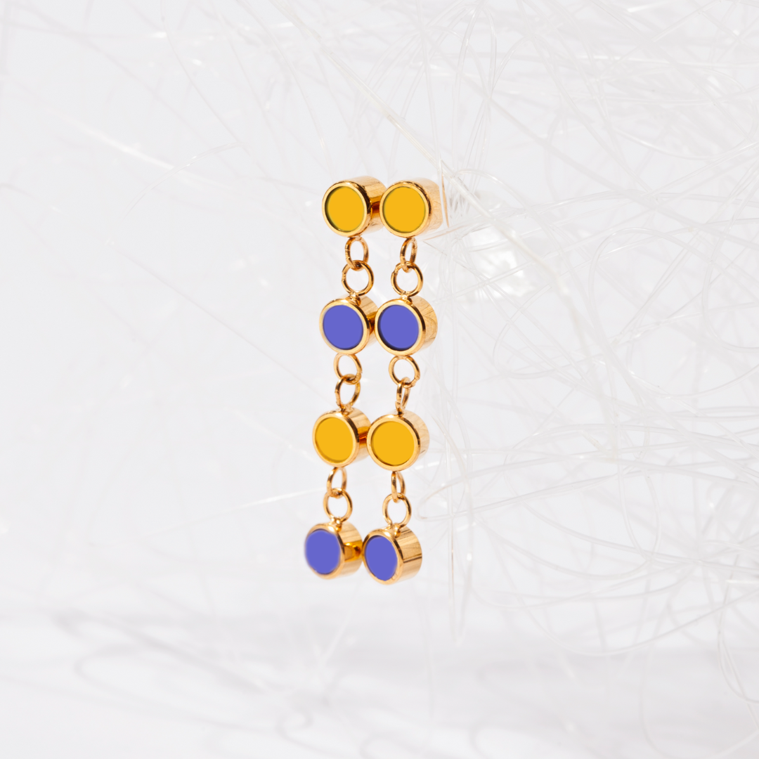 Long gold earrings with yellow and blue enamel charms from Jason Hyde.
