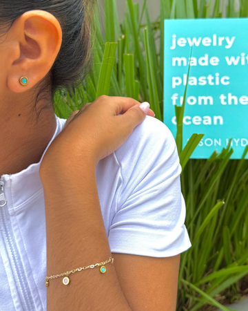 Charming Jason Hyde gold-tone bracelet and a turquoise stud earrings on a woman