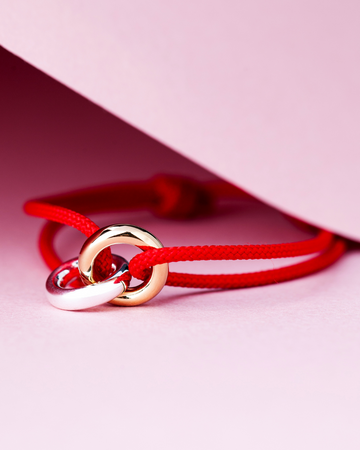 Close-up product shot of a Jason Hyde bracelet featuring a bright red cord