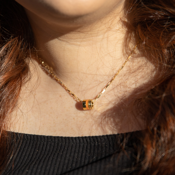 Jason Hyde gold necklace with orange and golden cylindrical pendant