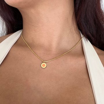 Close-up of a Jason Hyde necklace featuring a sustainable orange chip pendant