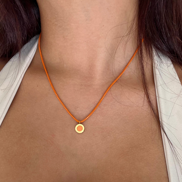 Orange painted brass necklace with a sustainable chip charm.