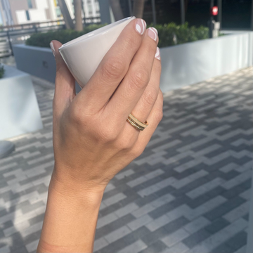 Close-up of hand with Jason Hyde gold and beige enamel ring
