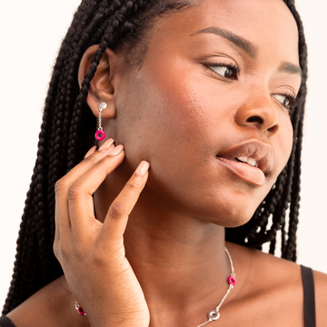 Woman wearing a delicate Jason Hyde necklace and dangling earrings in raspberry