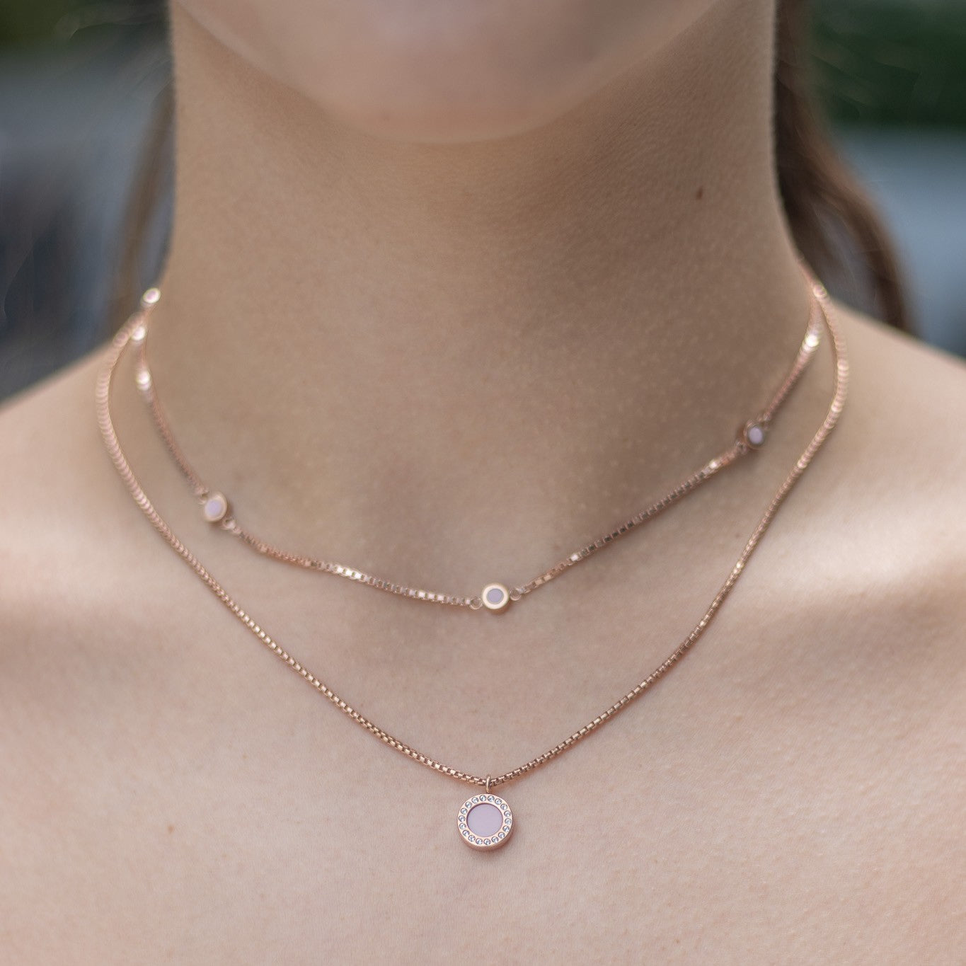 Elegant layered rose gold necklaces featuring soft pink recycled ocean plastic accents.