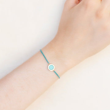 A wrist with a turquoise bracelet