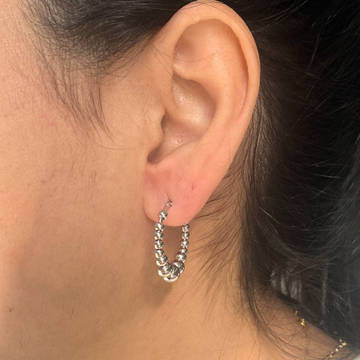 Stylish ear adorned with a Jason Hyde silver-tone beaded hoop earring.