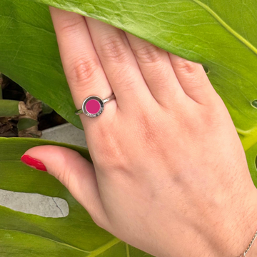 A raspberry ring with a charming pink accent, worn on a finger.