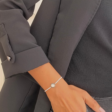 Close-up of Jason Hyde light pink bracelet featuring a delicate circular pendant