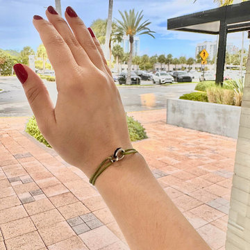 Minimalist green cord bracelet featuring a unique silver and black connecting detail.