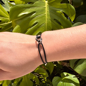 Close-up of a wrist wearing a sleek Jason Hyde black cord bracelet.