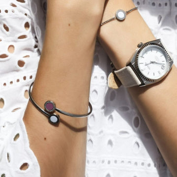 Wrists with Jason Hyde bracelet (white, plum charms) and silver watch.