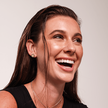 Close-up of woman wearing Jason Hyde beige chip stud earring with zirconia