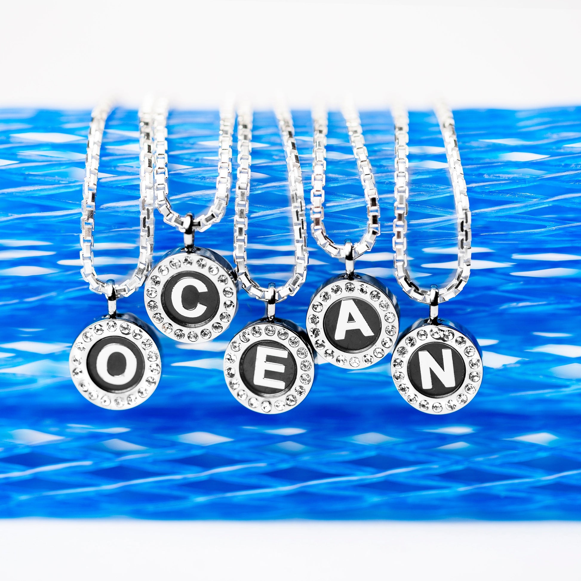 Oceangram necklaces with round pendants spelling OCEAN