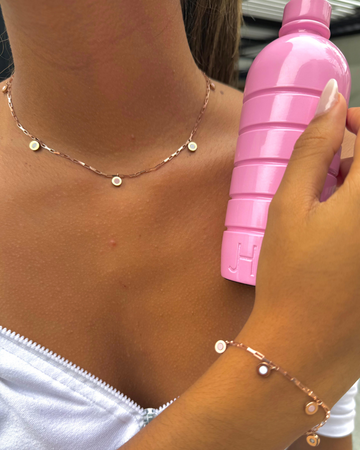 Close-up of a woman showcasing a Jason Hyde New Wave rose gold-tone jewelry set.