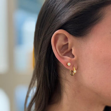 Gold stud and hoop earrings with white recycled ocean plastic accents