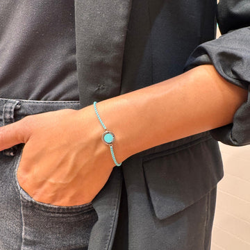 Turquoise and gold bracelet on a person's wrist.