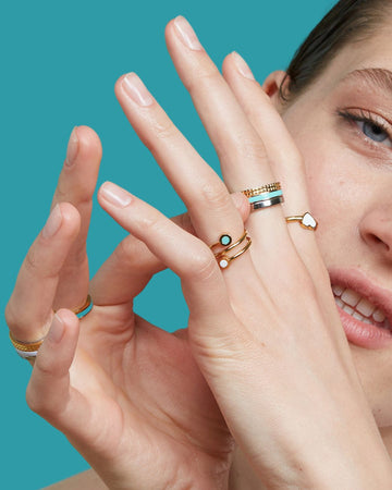 Close-up of a woman's hands displaying a variety of Jason Hyde rings