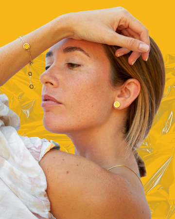 A woman with light brown hair and freckles wearing a Jason Hyde gold-tone bracelet