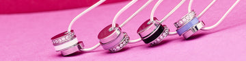 A flat lay of four silver necklaces with pendants.