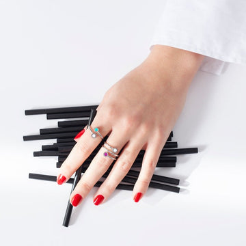 Close-up of a woman's hand showcasing several delicate silver rings