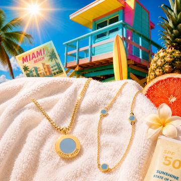 Gold summer jewelry on a beach towel with tropical Miami vibes and blue enamel details.