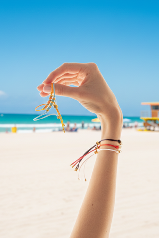 extra-img-Woman holding multi-colored adjustable thread bracelets with gold beads