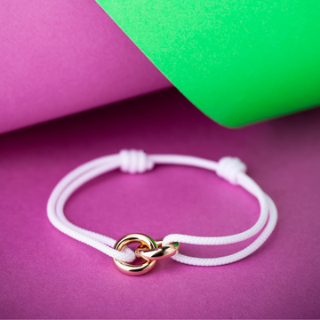 White adjustable cord bracelet with interlocking gold rings