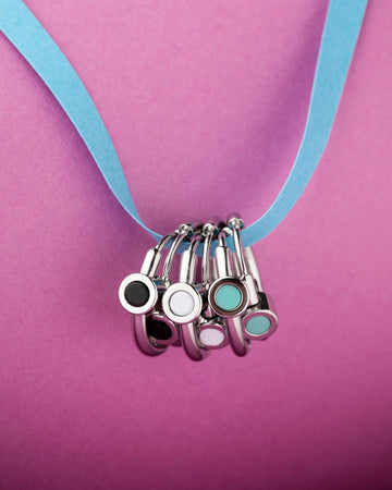Silver earrings with circular pendants in black, white, and turquoise chips