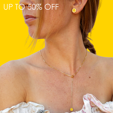 Woman wearing a minimalist gold lariat necklace and matching stud earrings with bright yellow enamel accents.