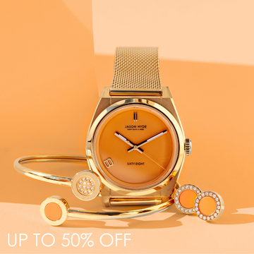 Gold mesh strap watch with an orange dial, matching gold bangle bracelet, and crystal-studded earrings set.