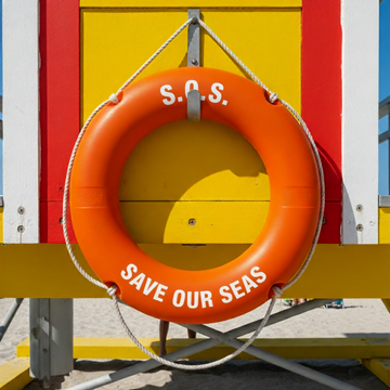 Orange lifebuoy Save Our Seas lifeguard tower beach