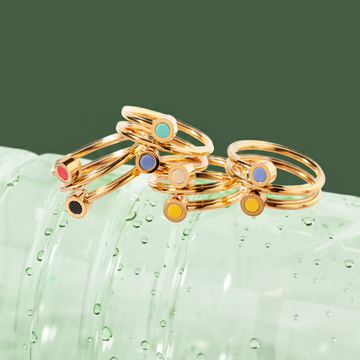 Stack of gold double-band rings with small colorful enamel dots 