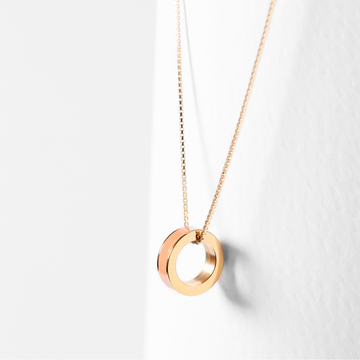 Gold chain necklace featuring a circular coral ring pendant.