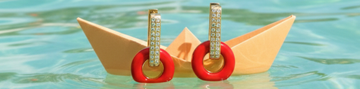 Earrings from the Lifesaver collection on a paper boat