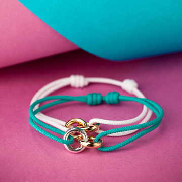 Adjustable white and teal cord bracelets with interlocking gold and silver circle charms