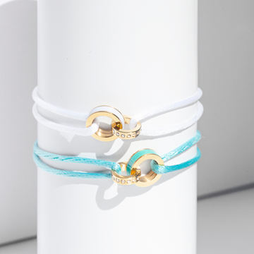 Stack of white and turquoise cord bracelets