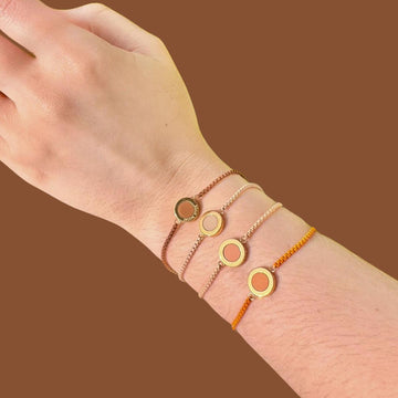A hand modeling four thin, layered bracelets