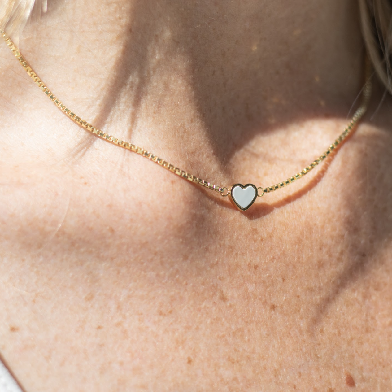 14k gold plated necklace with a white heart pendant.
