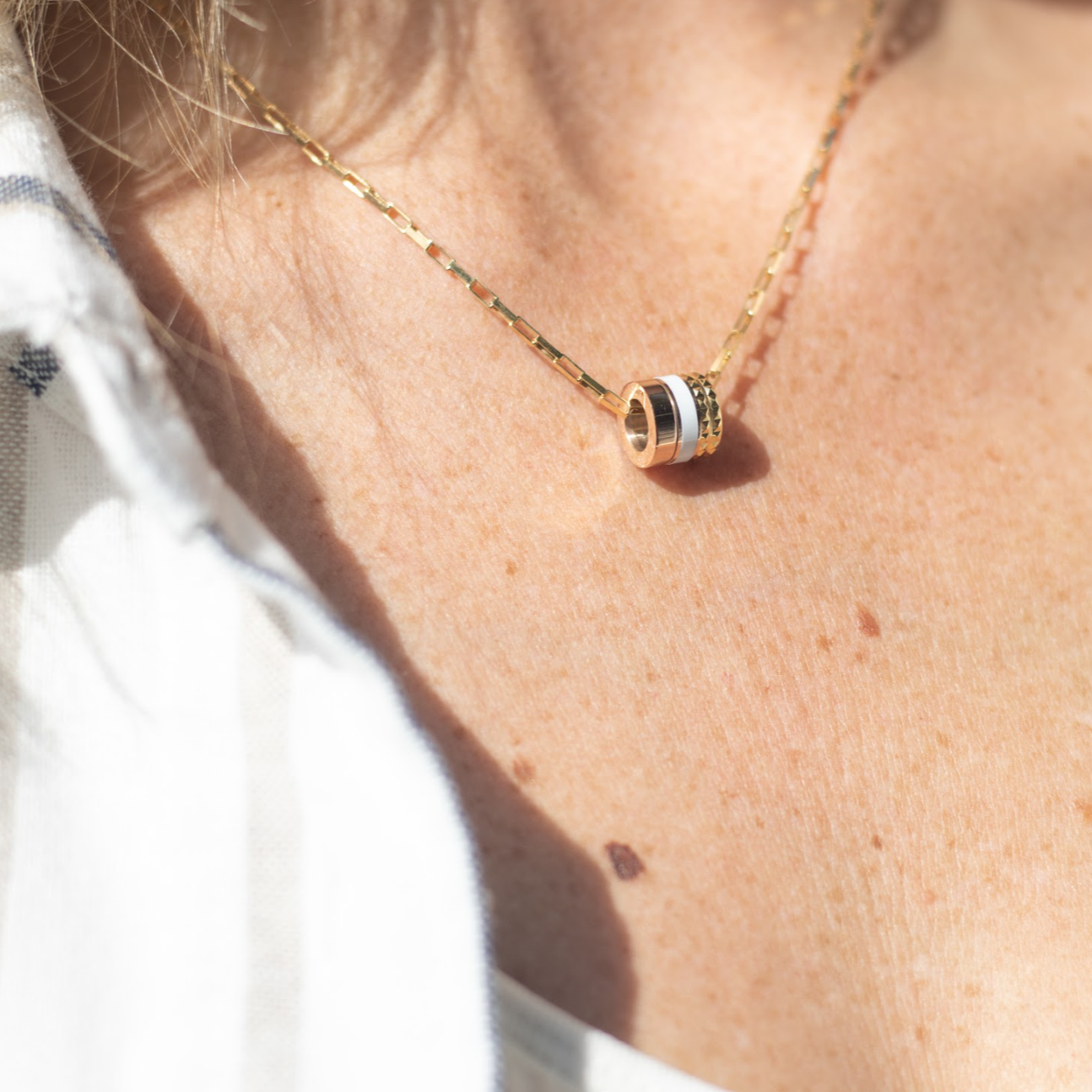 Gold necklace with white and gold pendant