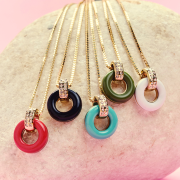A collection of five colorful sustainable necklaces with gold-plated pendants