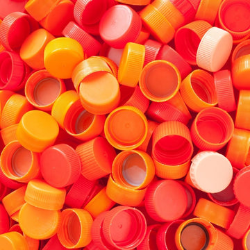 A pile of orange plastic bottle caps.