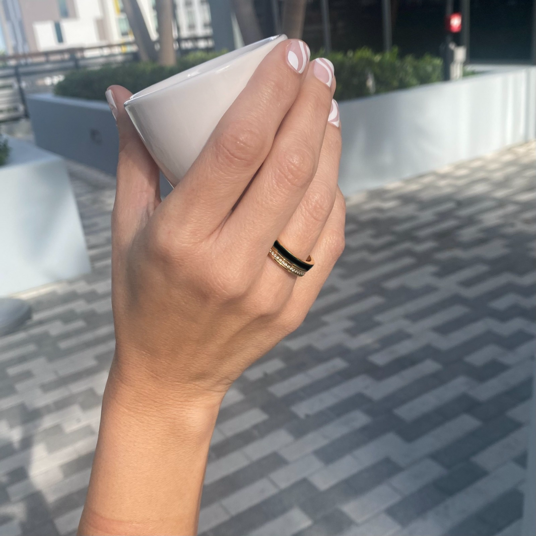 Close-up of hand with Jason Hyde gold and black enamel ring