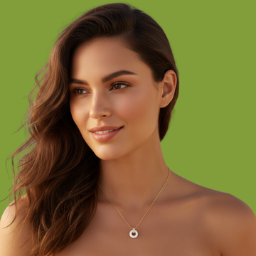 Smiling woman wearing a gold necklace with a white circular pendant