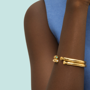 Close-up of a woman's arm wearing two Seacap Bangle