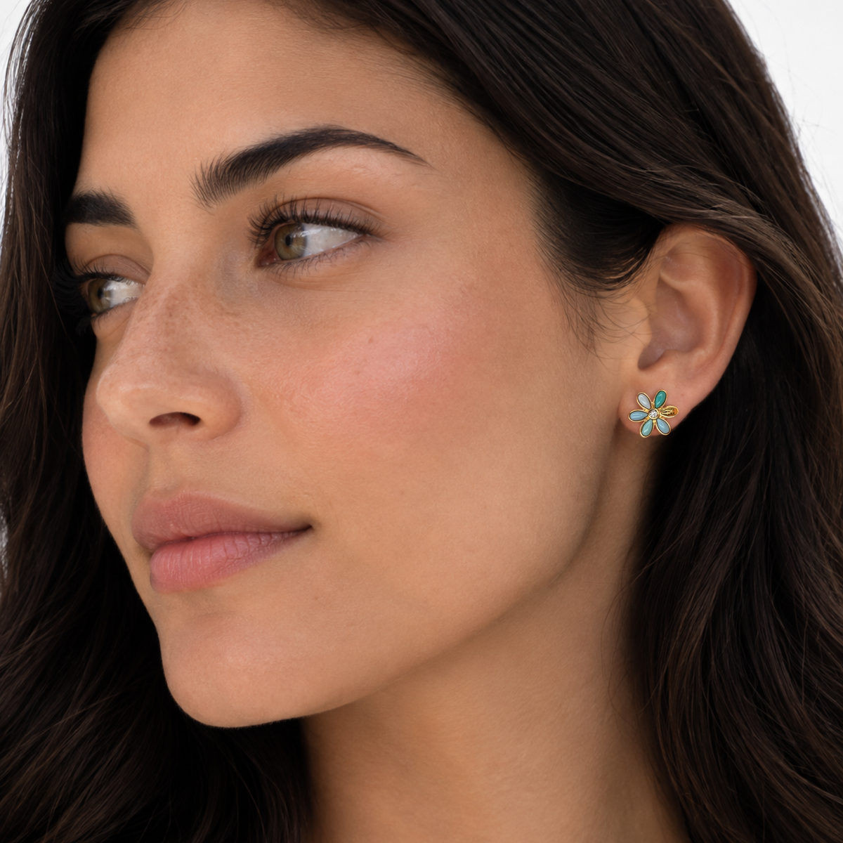 Turquoise flower stud earrings with gold-tone petals on a model