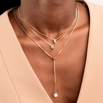 Layered gold chain necklaces with white and turquoise chips