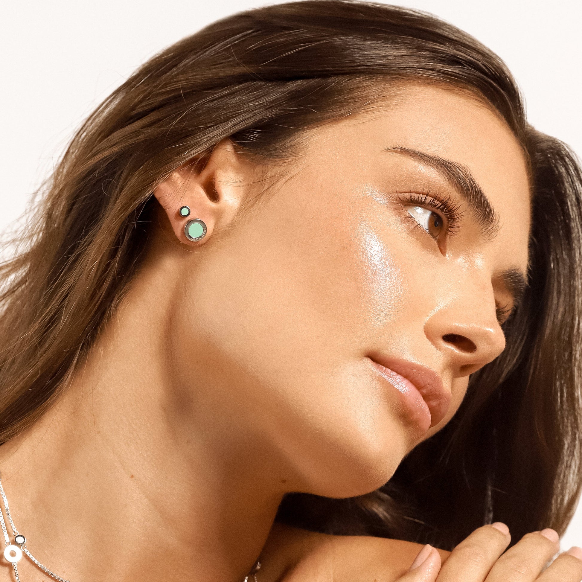 Woman's profile, showing two silver earrings with turquoise chips